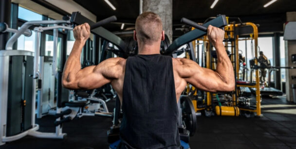 Homem realizando uma barra fixa na academia, demonstrando força e determinação no treino. - Fitsse