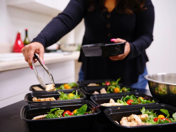 Uma mulher está cozinhando na cozinha, preparando ingredientes frescos com foco e dedicação. - Fitsse