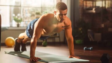 Homem fazendo flexões em um colchonete, focando na força e resistência muscular. - Fitsse