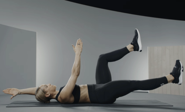 Mulher em roupa de treino preta, fazendo exercício, destacando força e dedicação no ambiente fitness. - Fitsse